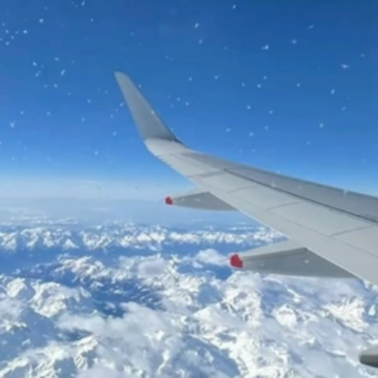 Asa de avião sobre montanhas, publicação da Plataforma Viagens